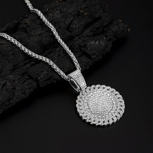 Detail of silver hip hop round pendant with iced out pavé diamonds on a black chain