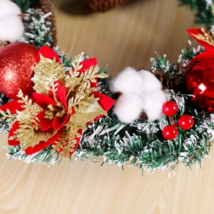 Détail d'une couronne de Noël avec boules rouges, coton et fleurs dorées