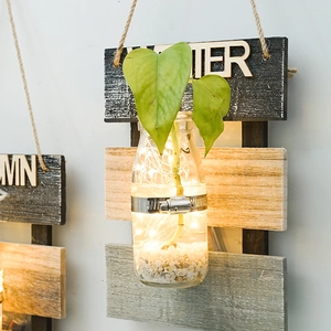 Jarrón hidropónico de pared con luces LED sobre tabla de madera para decoración casa