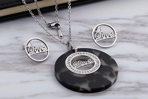 Detail of stainless steel necklace set with love engraving and resin tortoiseshell pendant