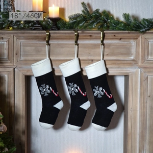 Set of three 18-inch black knitted Christmas stockings with candy cane and snowflake patterns