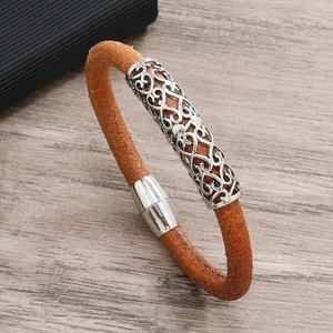 Detail of a brown woven leather bracelet with a silver patterned metal tube and magnetic clasp