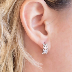 Close-up of olive leaf ear cuff in silver finish with micro-pave cubic zirconia on model