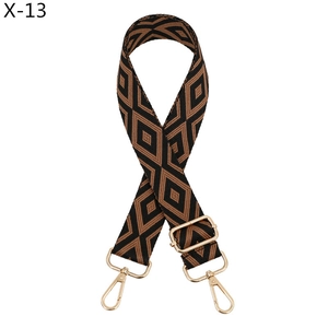 Detail of adjustable woven bag strap with brown diamond pattern and gold metal hooks