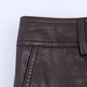 Primer plano de pantalón de cuero sintético marrón con detalles de costuras y borde de bolsillo