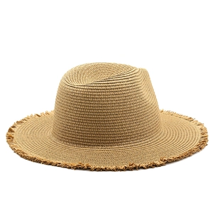 Detailed view of the frayed edge and crisscross weave on a raffia sun hat for travel