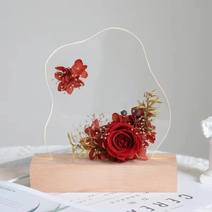 Vue macro de la veilleuse tulipe en verre avec roses rouges et socle LED en bois