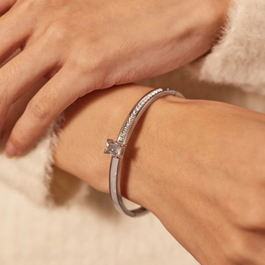 Close-up of silver steel cuff bracelet featuring a square zircon and pavé crystals