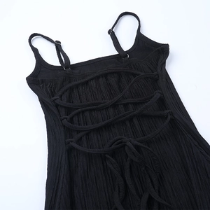 Détail d'une robe noire avec bretelles croisées au dos et tissu à texture gaufrée