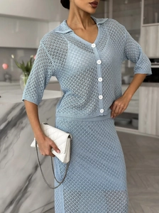 Close-up of light blue crochet knit texture and white buttons on the two-piece skirt set