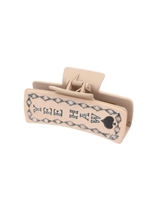 Detailed macro view of a beige rectangular claw clip featuring the Yee Haw cowboy design
