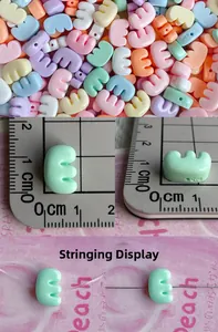 Macro detail of 1cm macaron resin letter beads showing size and threading display