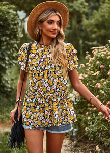 Detail of floral print top with ruffle hem and flutter sleeves in a garden setting