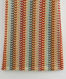 Detail of colorful crochet knit fabric with vibrant wave pattern and textured zigzag design