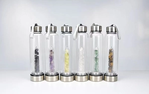 Detail of clear glass water bottles with six natural crystal columns and metal caps
