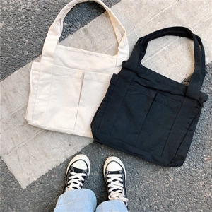Casual canvas tote bags in cream and black featuring large dual front pockets and wide straps