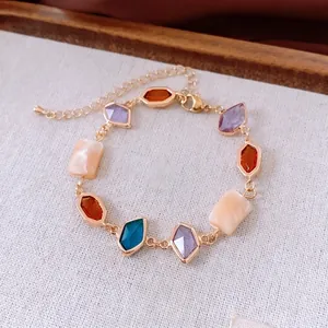 Vintage gold adjustable bracelet with colorful geometric gemstones and shell charms
