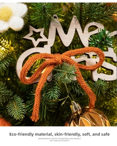 Détail du panneau en bois Merry Christmas avec nœud orange et ornements de fête
