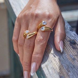 Detalle de anillos dorados ajustables con cristales de circón en forma de estrella y corazón