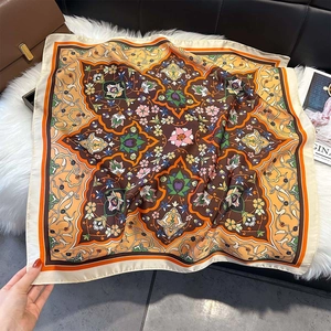 Detailed view of luxury satin silk scarf with vintage exotic floral pattern and orange border