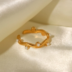 Close-up of 18K gold-plated irregular wavy ring with small white pearls on silk fabric