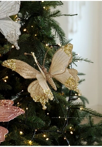 Dettaglio di farfalle natalizie glitterate con perle su un albero di Natale decorato