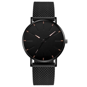 Macro shot of minimalist black mesh strap quartz watch with rose gold dial indexes