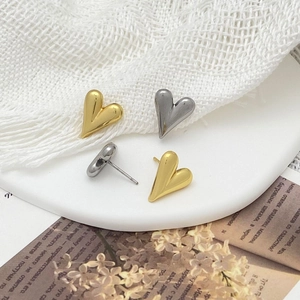 Détails de boucles d'oreilles en forme de cœur en or et argent poli sur plateau