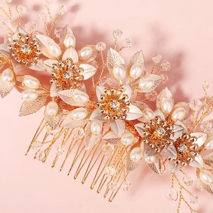 Detail of bridal hair comb with gold metal flowers, pearls and crystal beads