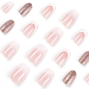 Short French press-on nails with pink ombre, glitter accents, and sparkling rhinestones