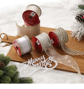 Detail showing assorted Christmas glitter ribbons and snowflake mesh on a wooden tray