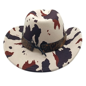 Detailed view of the cow print western cowboy hat with a brown decorative leopard band