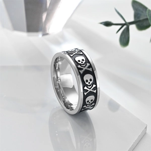 Detail view of vintage stainless steel skull ring with black enamel carvings