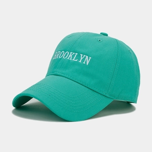 Detail of white Brooklyn embroidery on a mint green cotton twill baseball cap