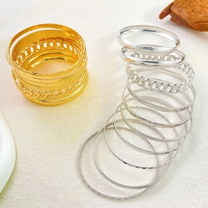 Nine-piece set of gold and silver chunky cuff bracelets with vintage textured metal designs