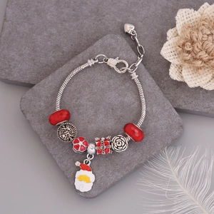 Detail of Christmas beaded bracelet with Santa Claus pendant on a stone background