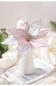 Close-up of pink and silver artificial poinsettia with gold glitter on petals in a vase