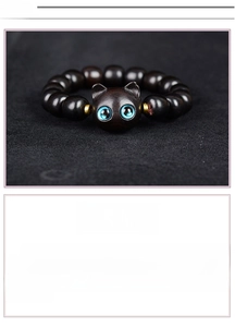 Gros plan d'un bracelet en perles de bois de santal avec un pendentif tête de chat