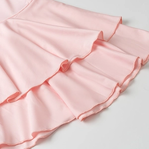 Detail of pink knitted layered dress featuring double-layered ruffled hem and fine stitching