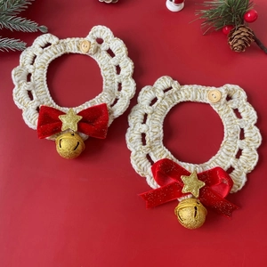 Detail of hand-knitted Christmas cat collar with red velvet bow, gold star, and bell
