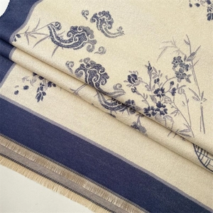 Gros plan d'un châle en cachemire beige avec motifs de fleurs de prunier et franges