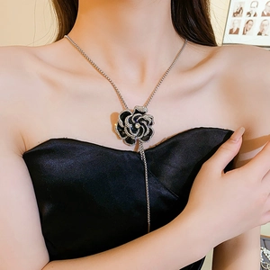 Close-up of a silver flower necklace with black oil-drop petals and rhinestones on a model