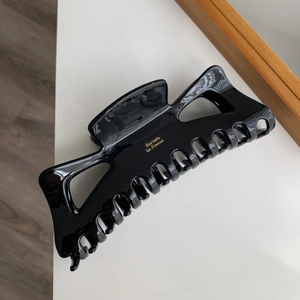 Vue détaillée de la pince à cheveux en acétate noire avec lettrage Barrette La France doré