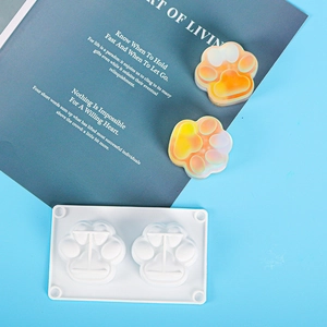 Detailed view of white silicone cat paw mold with two orange gradient resin samples