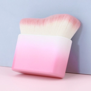 Macro detail of curved wavy foundation brush with pink gradient bristles and flat handle