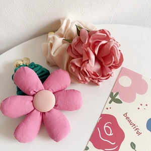 Detailed view of pink floral fabric scrunchies and rose hair ties on a white surface