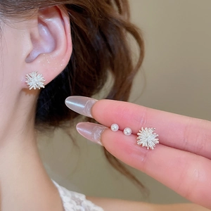 Detail of silver firework studs and pearl earrings set shown on model ear