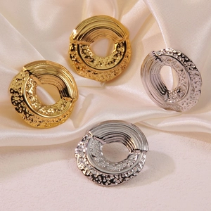 Detail view of gold and silver titanium earrings with spiral and hammered textures