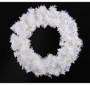 Close-up of white plush Christmas wreath showing soft texture on a dark background