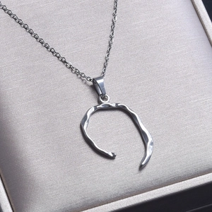 Detailed view of silver irregular flow line pendant necklace on silk texture gift box